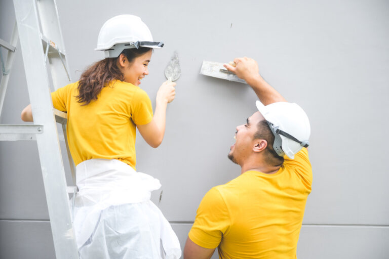 Un couple réalise des travaux et pose du MAP sur un mur extérieur