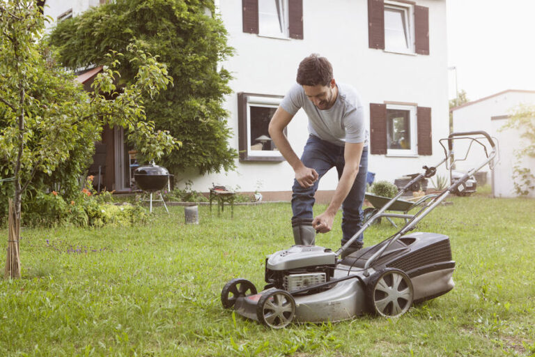 Un jardinier entretien sa tondeuse à gazon pour la stocker pour l'hiver