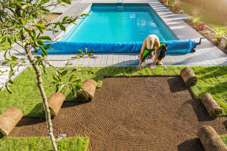 Un homme qui met du gazon synthétique au bord de sa piscine