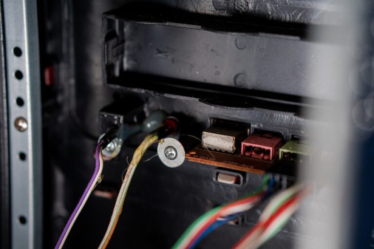 Main tenant un domino ou connecteur, en train de raccorder quatre fils sur trois