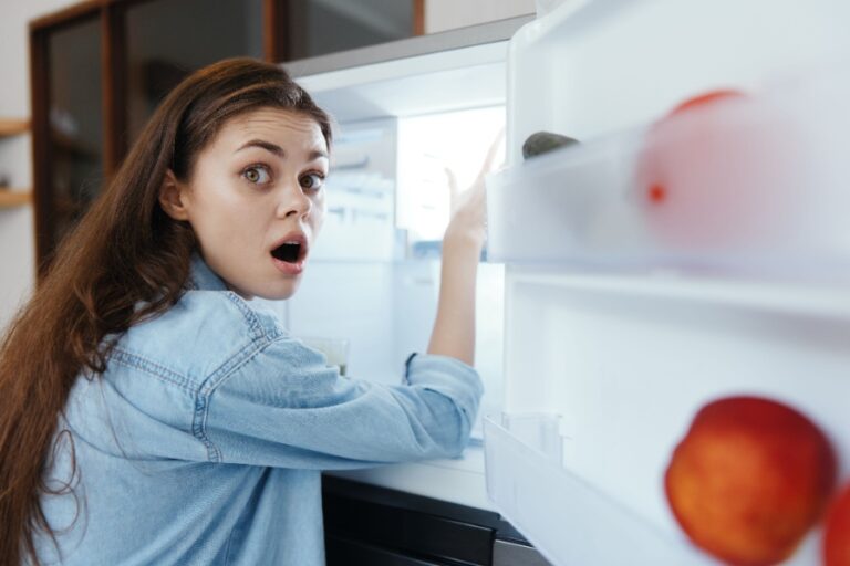 Un réfrigérateur ouvert montre des étagères avec des aliments réchauffés après une coupure de courant prolongée