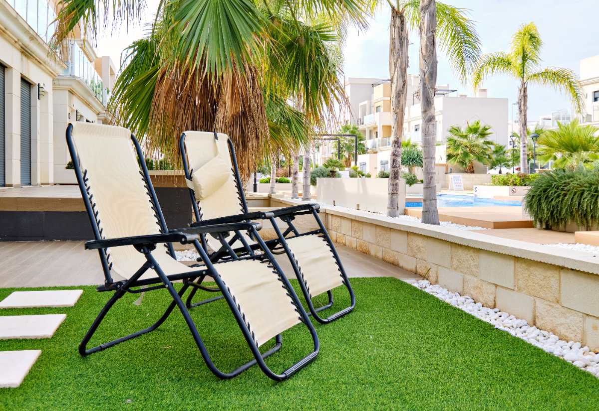 Des chaises placées sur du gazon synthétique dans un jardin