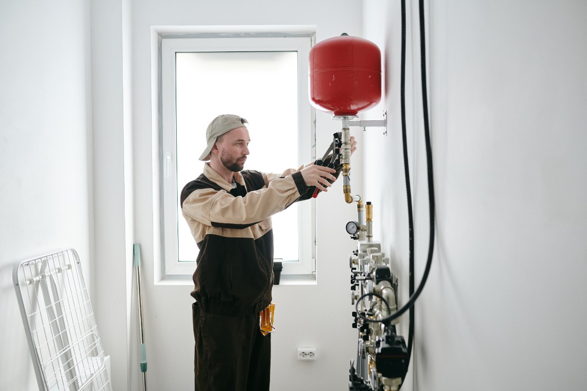 Un technicien qui installe une vase d'expansion sanitaire