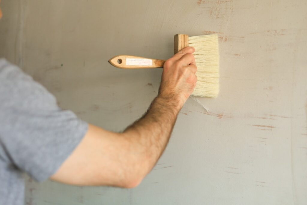 Main d'un homme faisant enduire le mur
