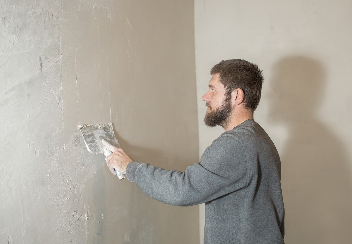 Un homme qui réalise de l'enduit sur le mur