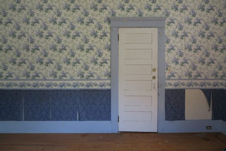 Du papier peint posé sur le mur avec une porte blanche