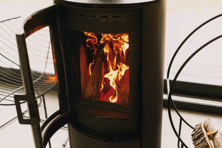 Un poêle à bois Invicta ouvert avec du feu