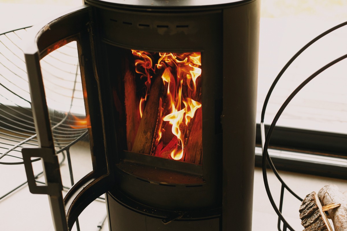 Un poêle à bois Invicta ouvert avec du feu