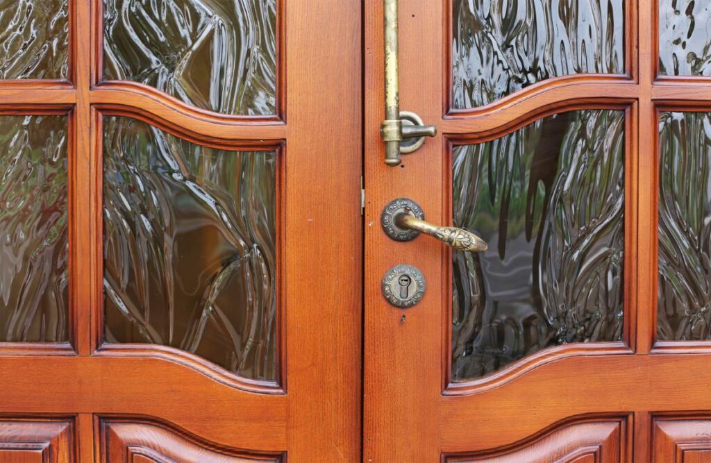 Une porte d'entree ornée en bois et en verre