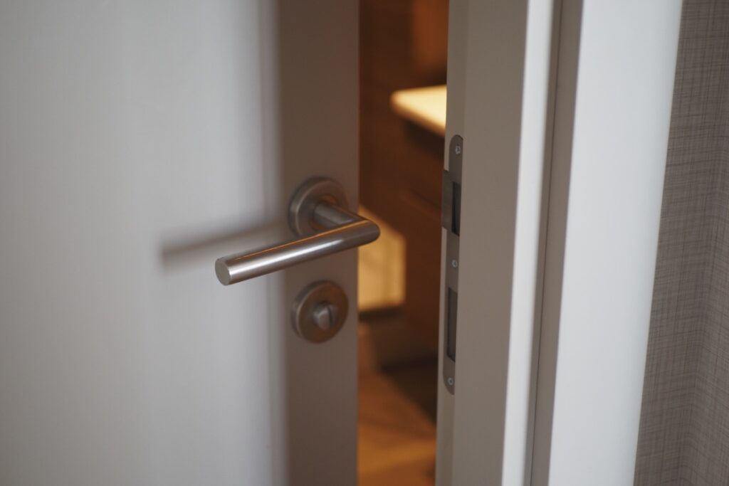 Une porte d'entrée ouverte avec une poignée argentée