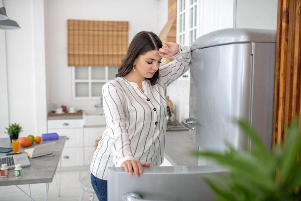 Une femme qui regarde la nourriture dans le frigo