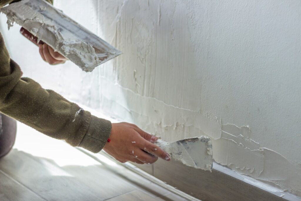 Un homme qui applique de l'enduit sur le mur