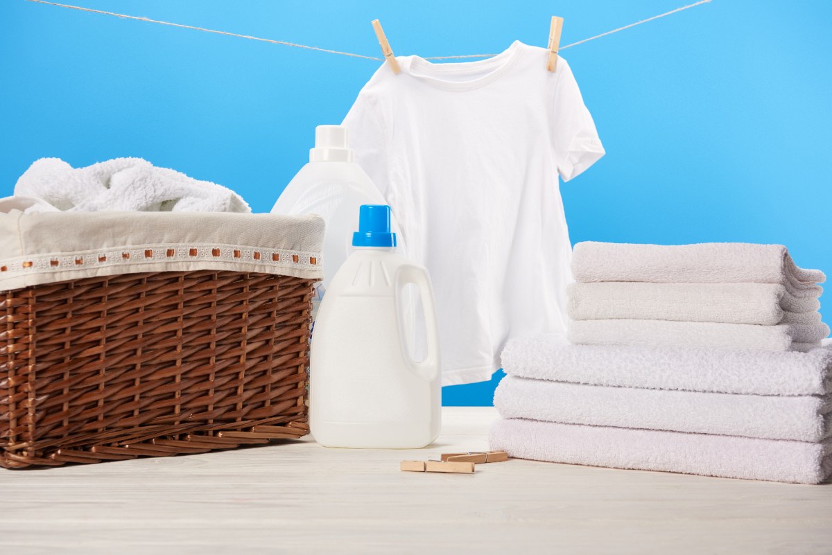 Lessive avec du détergent et des vêtements blancs propres