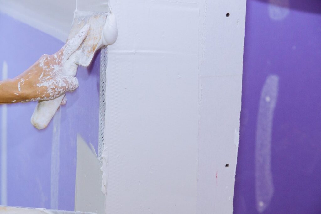Un ouvrier qui applique du plâtre sur le mur
