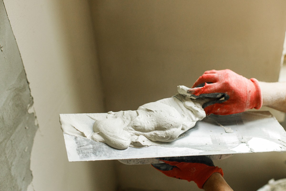 Un plâtrier lissant du plâtre sur une truelle
