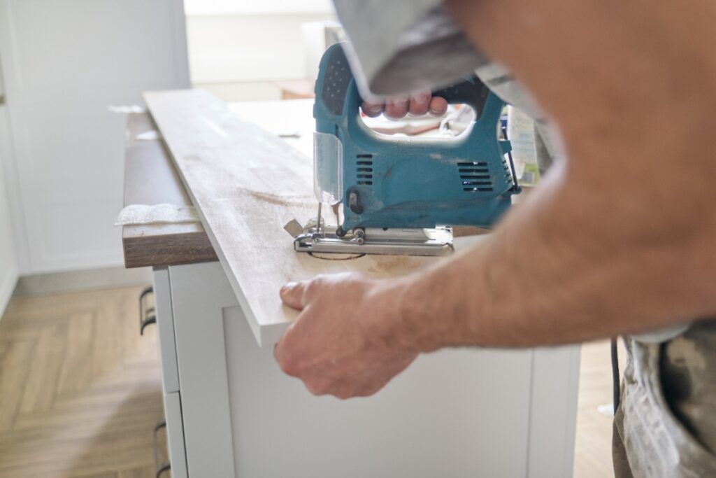 Un artisan qui découpe du bois avec une scie sauteuse