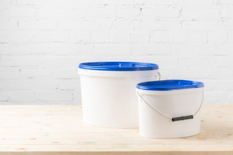 Deux seaux blancs avec des couvercles bleu sur la table