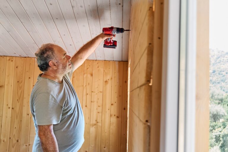 Un homme fixant du lambris sur du placo