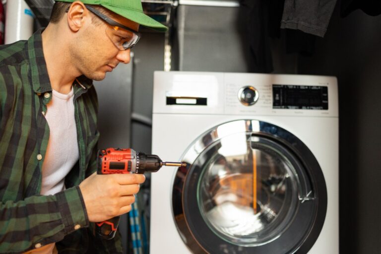 Un homme qui répare une machine à laver