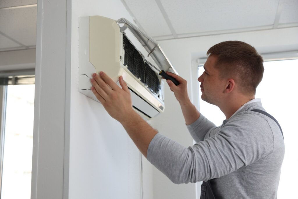 Un technicien qui répare un système de ventilation