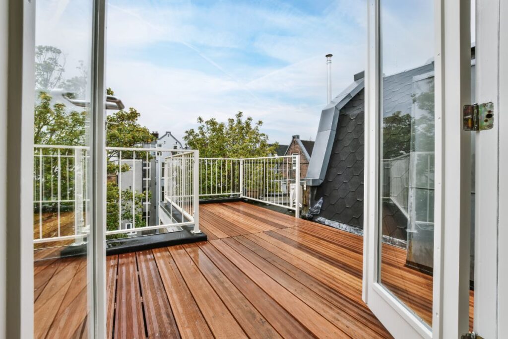 Une porte ouverte et une belle terrasse en bois