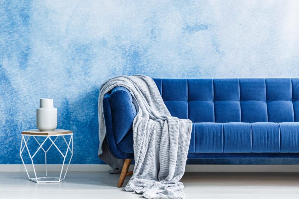 Un canapé bleu avec une couverture 