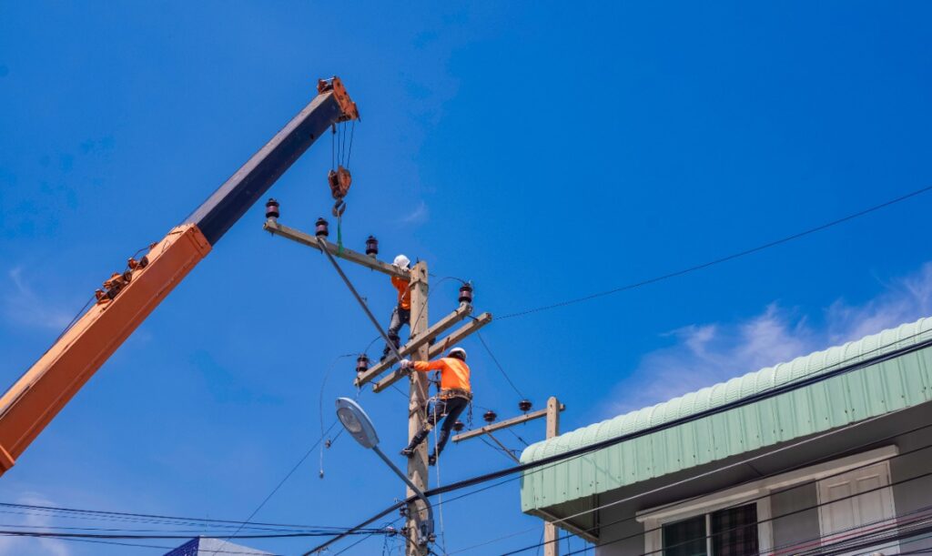 Un électricien installant un poteau électrique