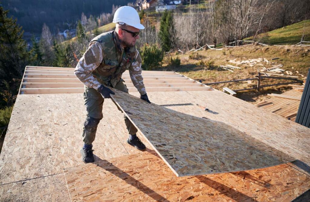 Un ouvrier posant du plancher en OSB