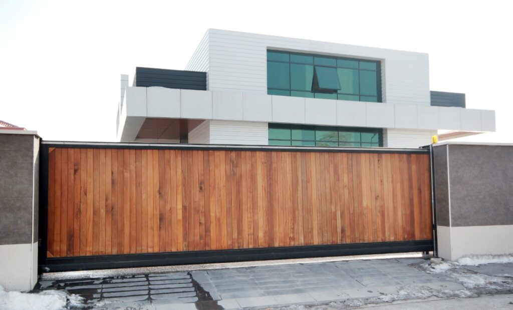 Façade de maison moderne derrière un portail de sécurité